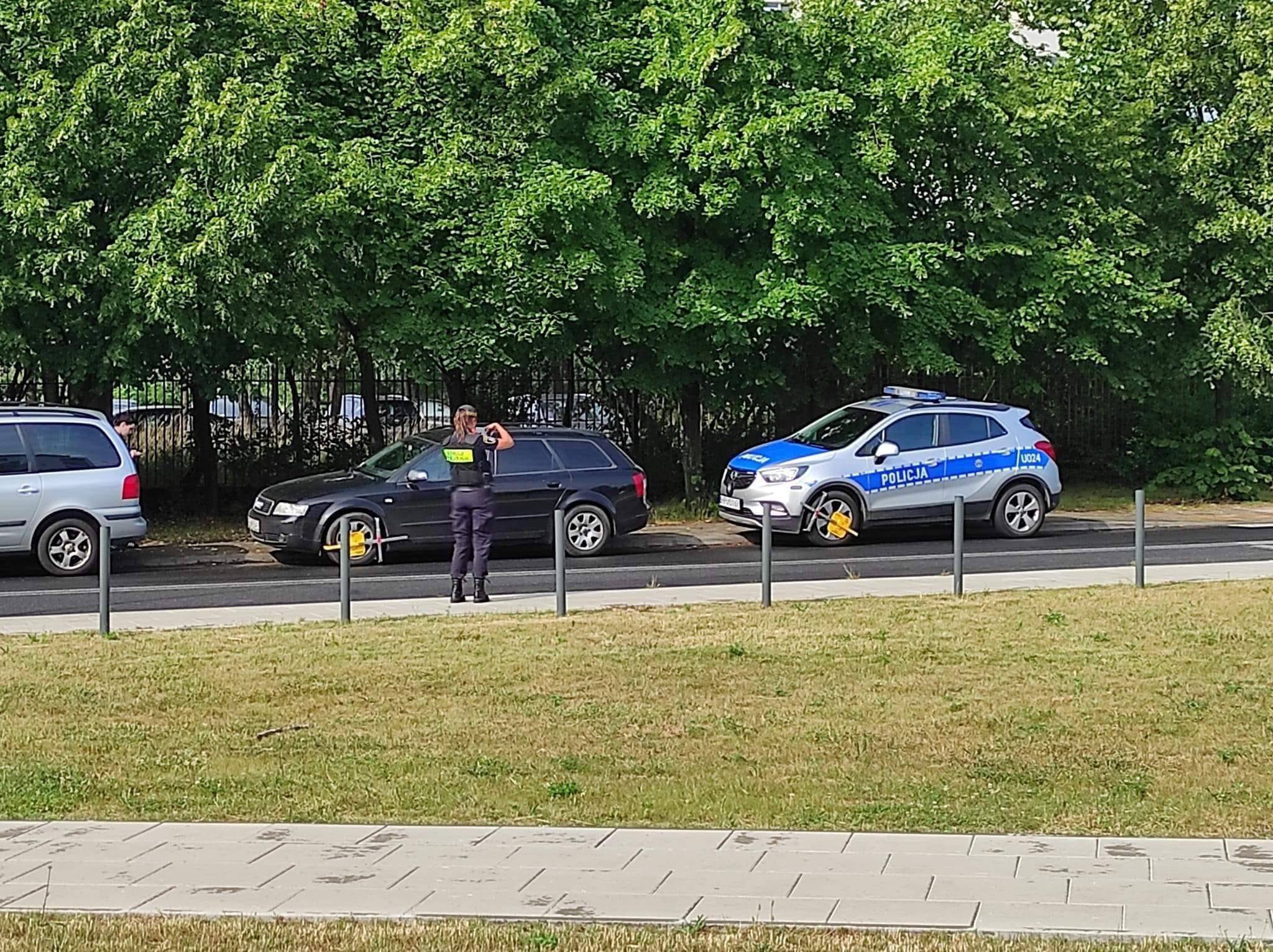 Policyjny radiowóz z blokadą na kole