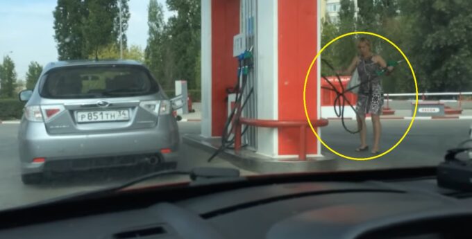 Kobieta tankuje Subaru na stacji