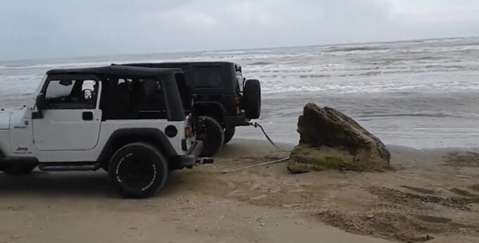 Dwa Jeepy próbowały ruszyć głaz z plaży