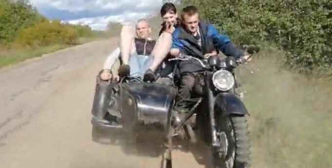 Trzech pijanych Rosjan holowanych na motocyklu