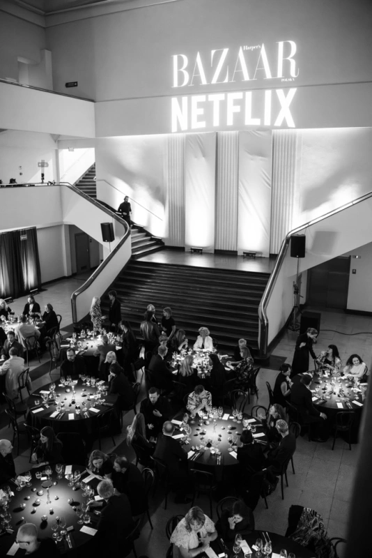 Kolacja Harper's Bazaar i Netflix Polska w Muzeum Emigracji w Gdyni, z eleganckimi stołami i oświetleniem.