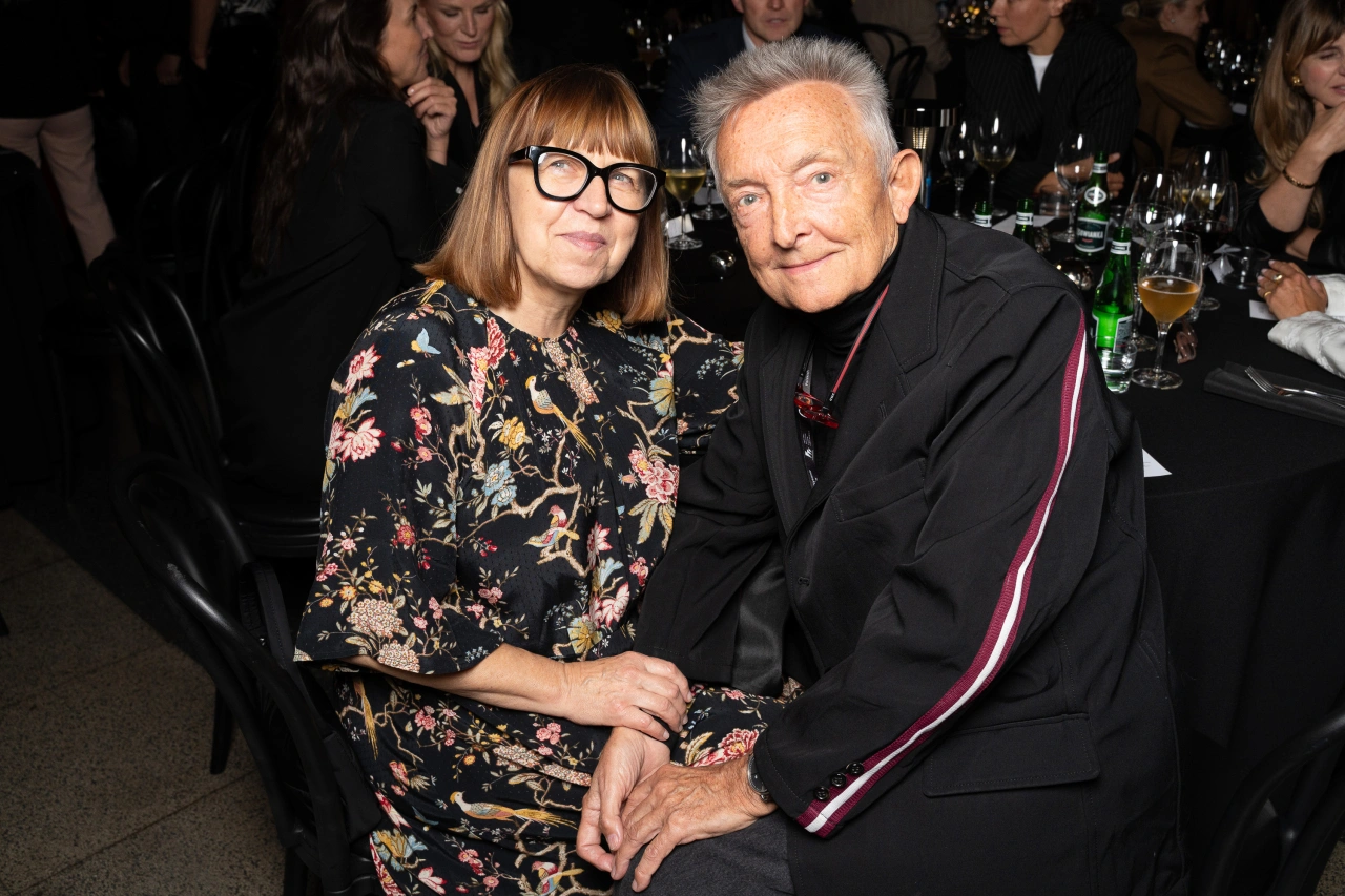 Ewa Puszczyńska i Waldemar Pokromski siedzą razem przy stole podczas wydarzenia towarzyskiego.