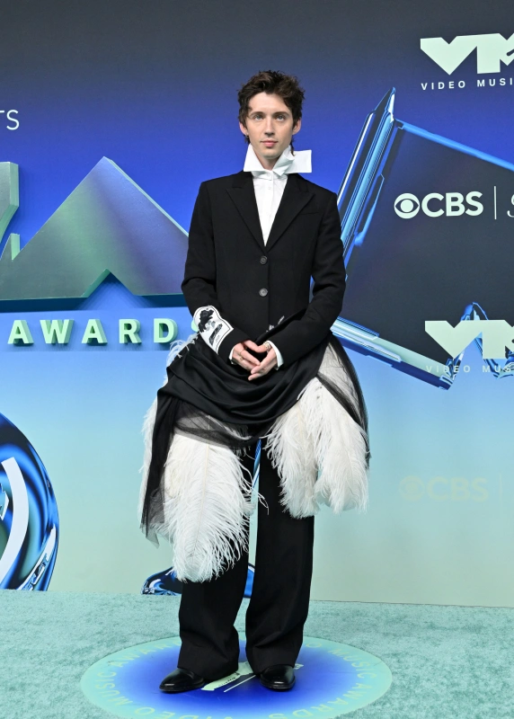 Troye Sivan w eleganckim stroju na gali VMA, z unikalnym elementem z piór i obszerna spódnicą.